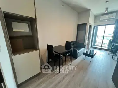 Modern living room with sleek furniture and balcony access in a stylish apartment.