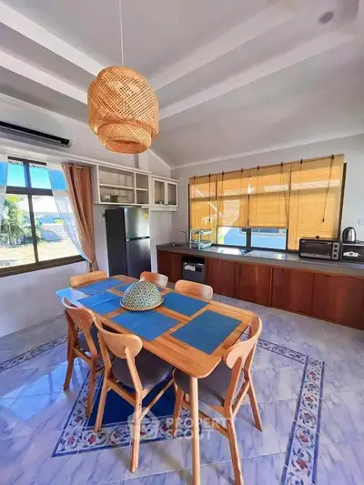 Charming kitchen with wooden dining set and modern appliances, featuring a cozy open layout and natural light.