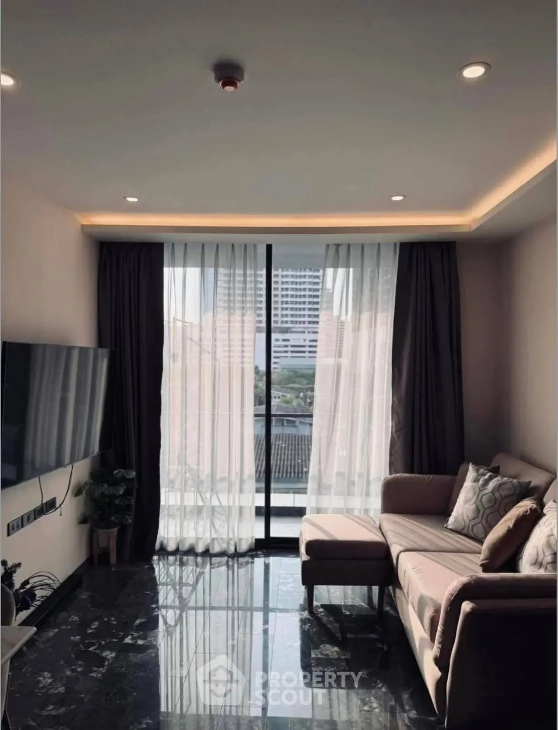 Modern living room with sleek marble flooring and large window offering city view.