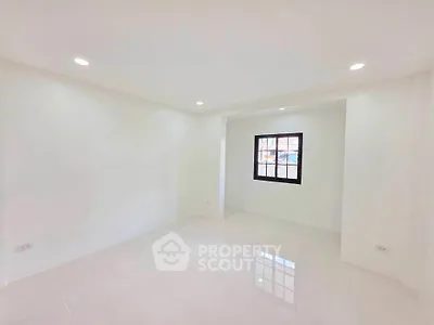 Spacious empty room with bright lighting and a window, ideal for customization.