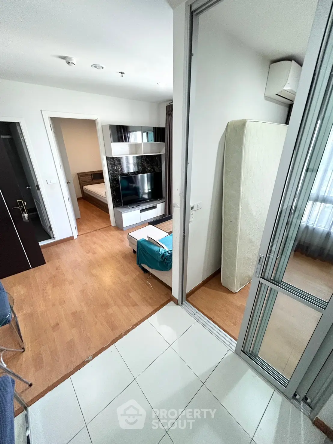 Modern apartment interior with open layout, featuring a cozy living area and bedroom with sleek furnishings.