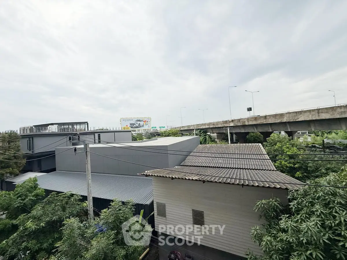 Modern industrial building with lush greenery and highway view