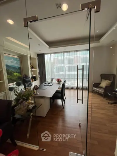 Elegant study room with glass door, wooden flooring, and natural light