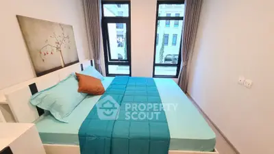 Modern bedroom with large windows and stylish decor in a contemporary apartment.