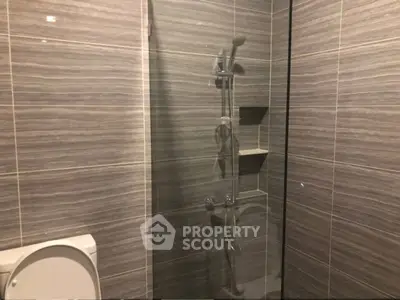Modern bathroom with sleek gray tiles and glass shower enclosure
