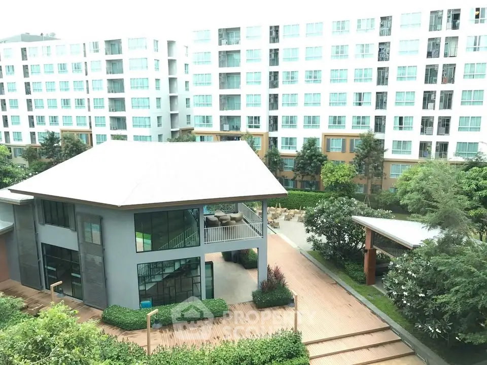 Modern apartment complex with lush greenery and spacious outdoor areas.