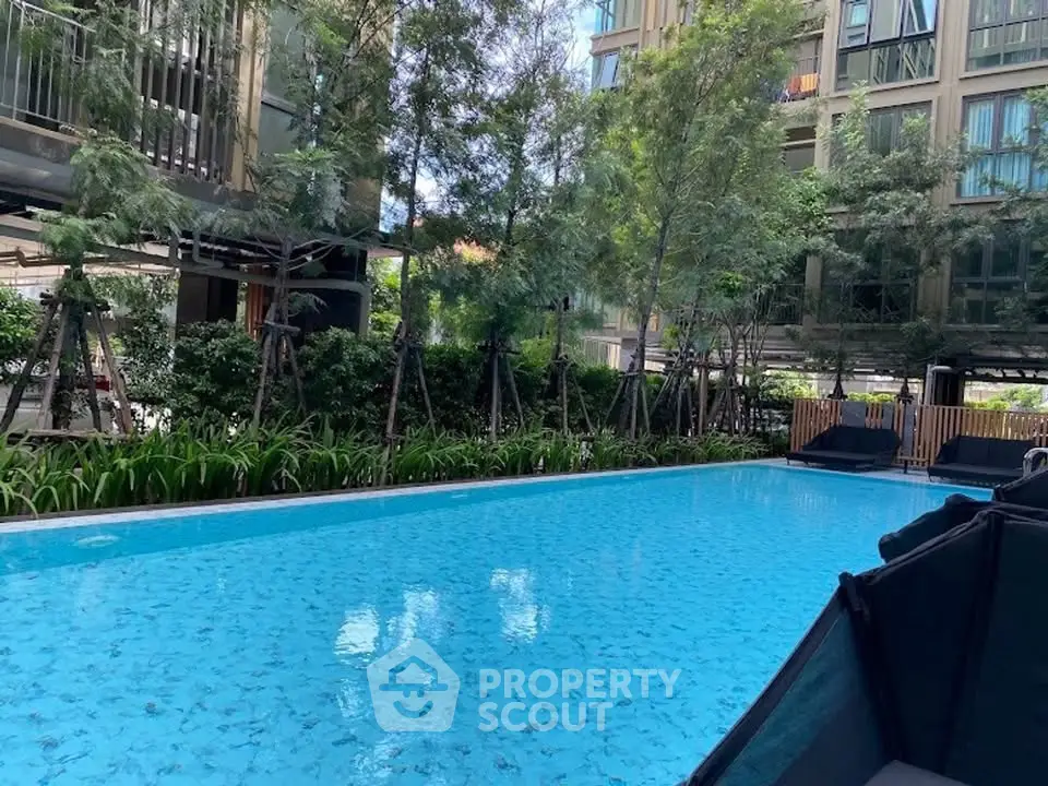 Luxurious residential pool surrounded by lush greenery and modern architecture, perfect for relaxation and leisure.