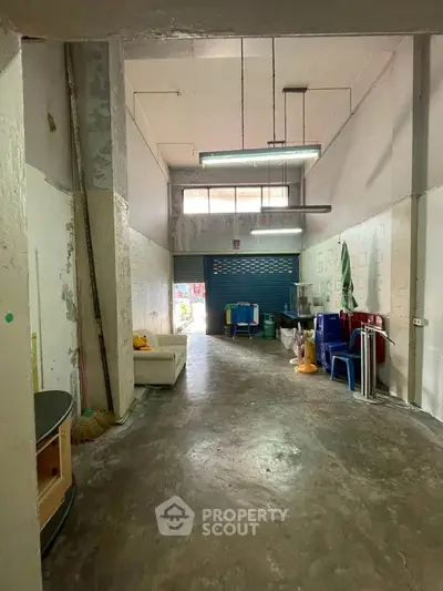 Spacious industrial-style interior with high ceilings and natural light, ideal for creative workspace or studio.