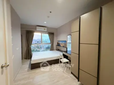 Modern bedroom with city view, featuring sleek furniture and large window for natural light.