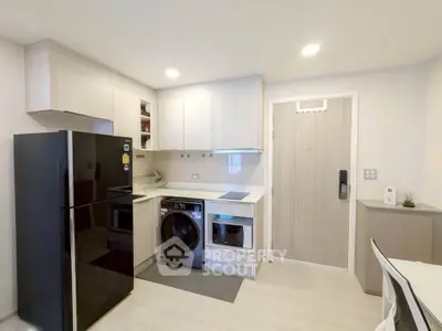 Modern kitchen with sleek appliances and stylish cabinetry in a contemporary apartment.