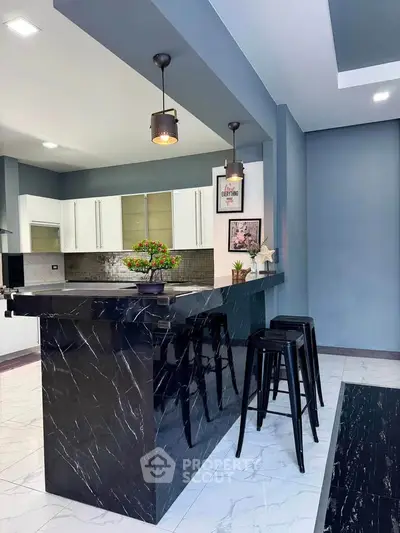 Modern kitchen with sleek black marble island and stylish bar stools