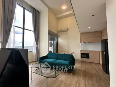 Modern living room with high ceilings, large windows, and open kitchen layout.