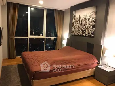 Luxurious bedroom with city view, modern decor, and cozy ambiance in high-rise apartment.