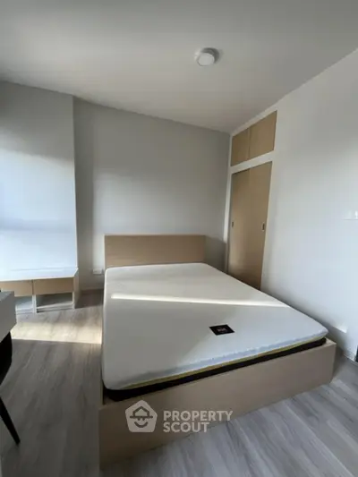 Modern minimalist bedroom with wooden flooring and built-in wardrobe