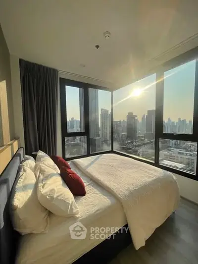 Luxurious bedroom with stunning city view and large windows, perfect for urban living.