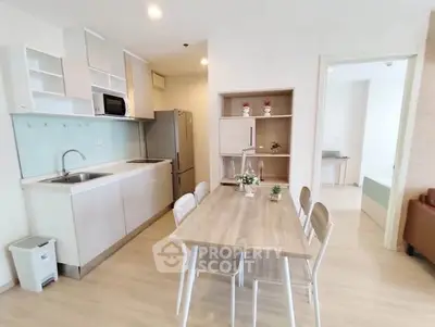 Modern kitchen with dining area featuring sleek cabinetry and contemporary design.