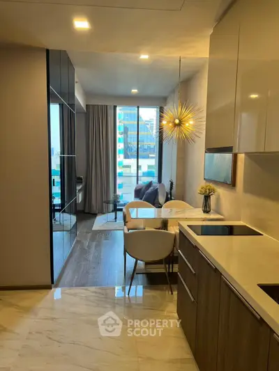Modern open-layout kitchen and living area with stylish lighting and city view.