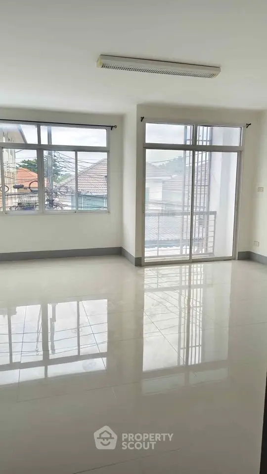 Spacious empty room with large windows and balcony access, offering abundant natural light and modern appeal.