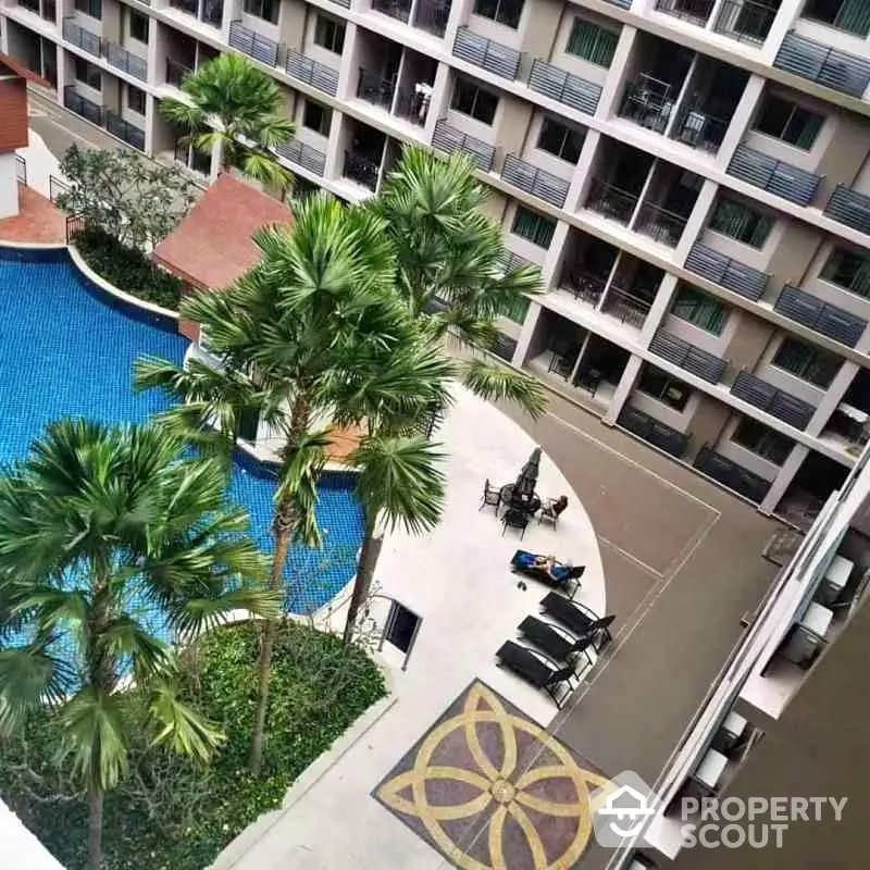 Luxurious apartment complex with pool and palm trees, perfect for resort-style living.