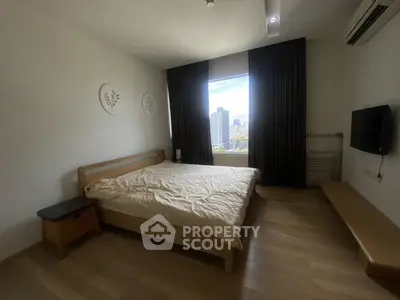 Spacious bedroom with city view, wooden flooring, and modern decor