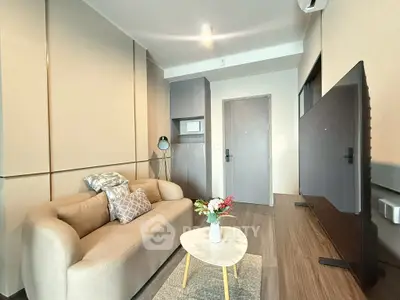 Modern living room with cozy sofa, stylish decor, and large TV in a contemporary apartment.