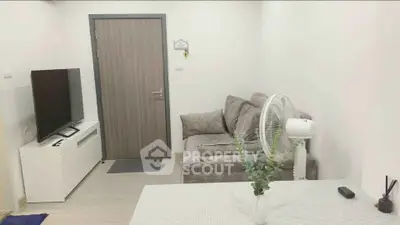 Cozy living room with modern decor and flat-screen TV, perfect for relaxation.