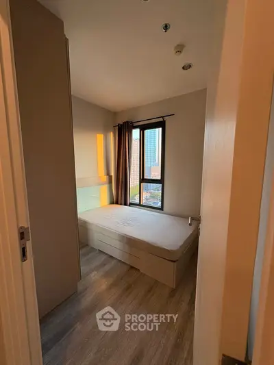 Cozy bedroom with city view, featuring a comfortable bed and modern decor, perfect for urban living.