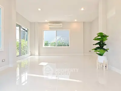 Spacious and bright living room with large windows and modern air conditioning.