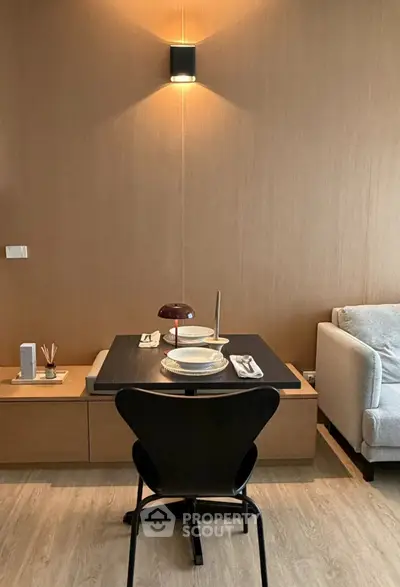 Modern dining area with sleek furniture and warm lighting in a stylish apartment.