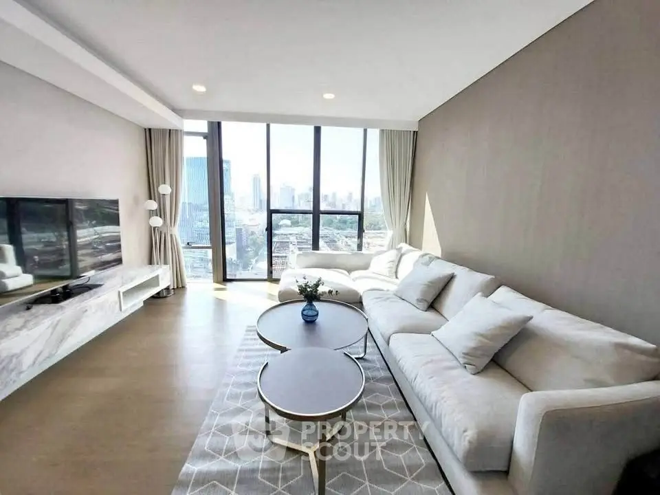 Spacious modern living room with panoramic city view and elegant furnishings.