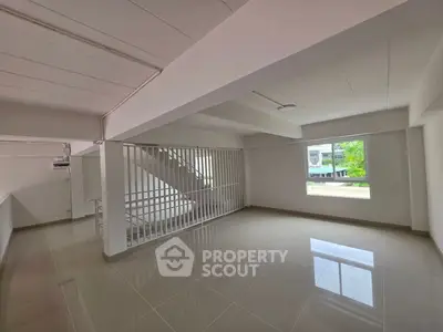 Spacious modern interior with large window and sleek tiled flooring