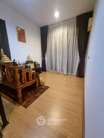 Elegant living room with wooden flooring and stylish curtains, perfect for cozy gatherings.