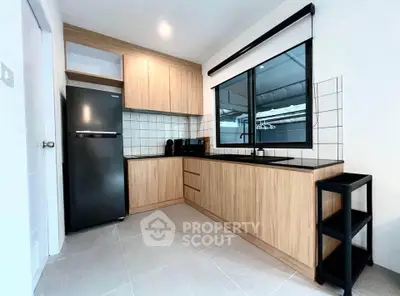 Modern kitchen with sleek black appliances and wooden cabinetry