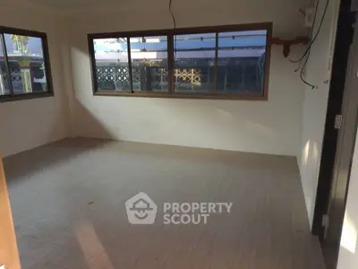 Spacious unfurnished room with large windows and natural light, ideal for customization.