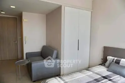 Modern bedroom with stylish gray sofa and cozy bed