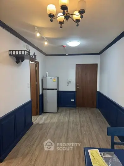 Charming interior with elegant lighting and modern fridge in cozy space.