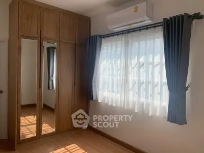 Bright bedroom with wooden wardrobe and large window