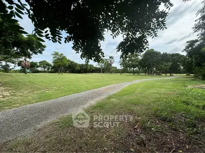 Expansive green garden with lush trees and a winding path, perfect for outdoor activities and relaxation.