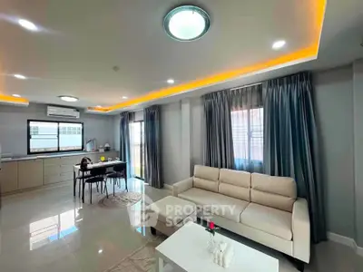 Spacious modern living room with open kitchen and elegant lighting