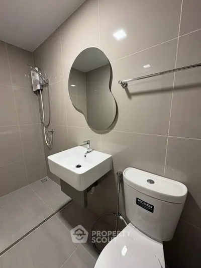 Modern bathroom with sleek fixtures and unique mirror design in contemporary apartment.