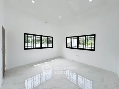 Spacious and bright room with large windows and glossy marble flooring, perfect for modern living.