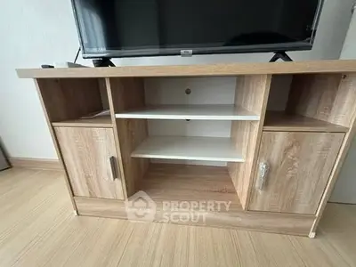 Modern wooden TV stand with open shelves and cabinets in a stylish living room.