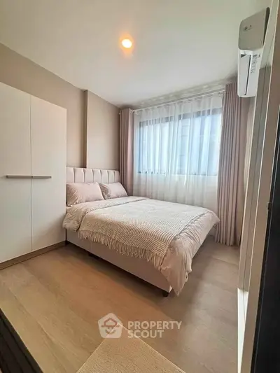 Cozy bedroom with modern decor and ample natural light, featuring a comfortable bed and stylish curtains.