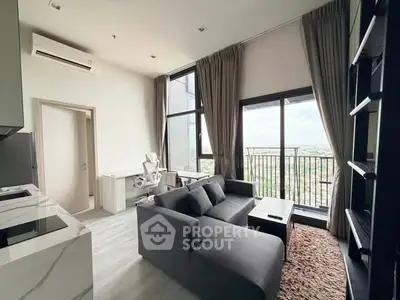 Modern living room with balcony view, sleek furniture, and natural light in a high-rise apartment.