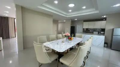 Spacious dining area with elegant marble table and modern kitchen in open layout design.
