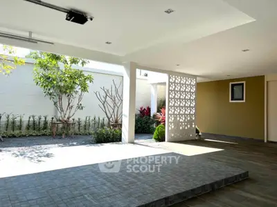 Spacious modern patio with elegant design and lush garden view, perfect for relaxation and outdoor gatherings.