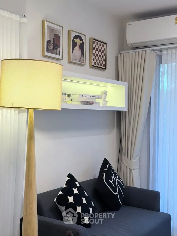 Stylish living room with modern decor, featuring a cozy sofa, elegant floor lamp, and chic wall art.