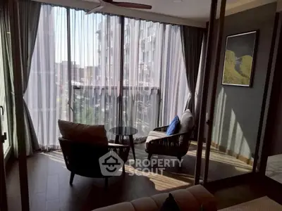 Chic modern living room with floor-to-ceiling windows and cozy seating area.