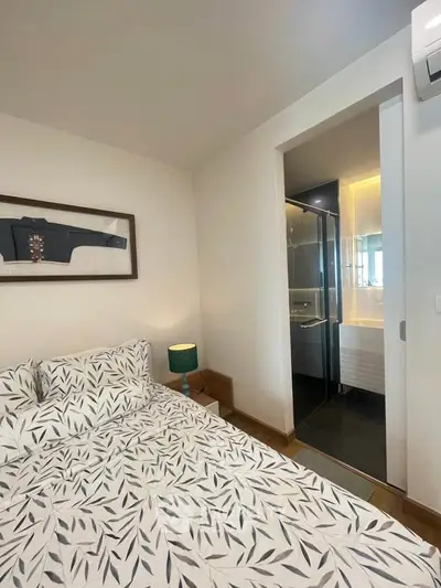 Cozy bedroom with modern decor and ensuite bathroom, featuring stylish bedding and ambient lighting.