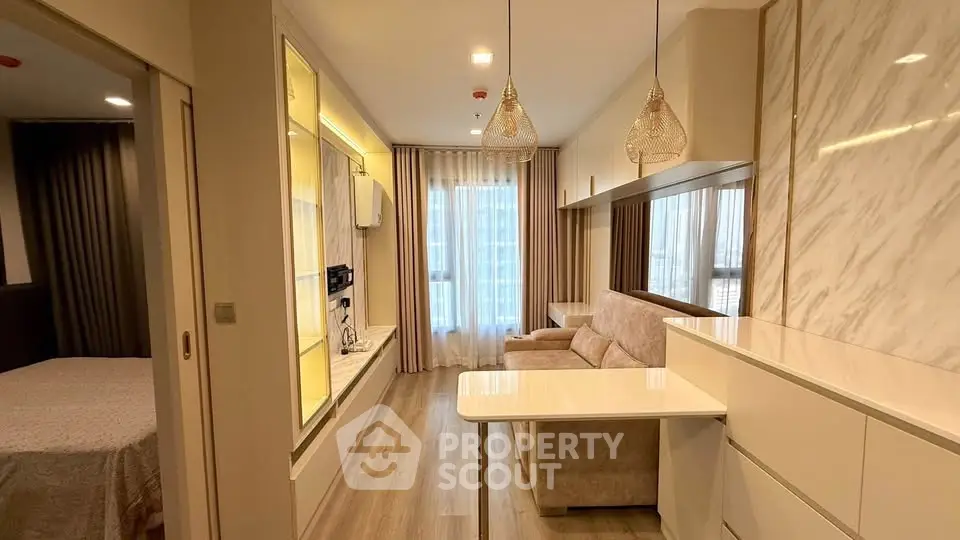 Modern living room with elegant decor and open layout, featuring stylish lighting and cozy seating area.